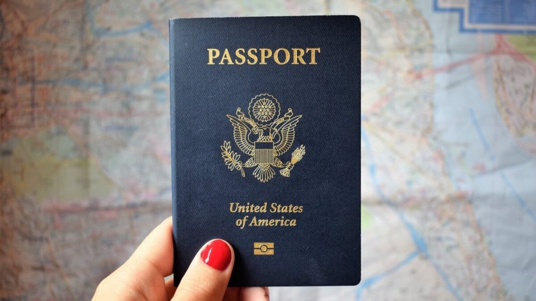 person with red nails holding us passport
