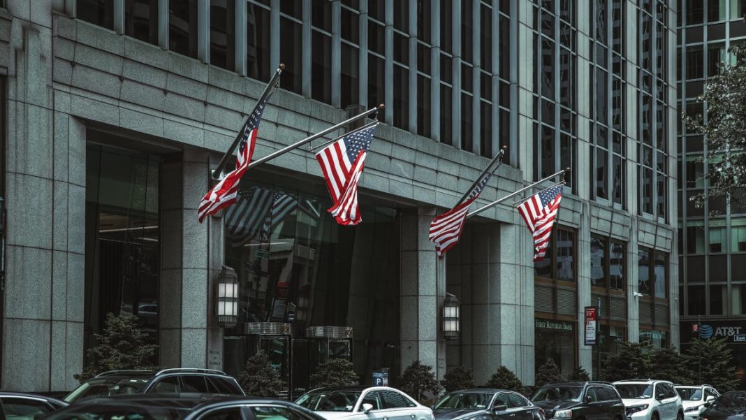 us flags hanging on nyc gray building