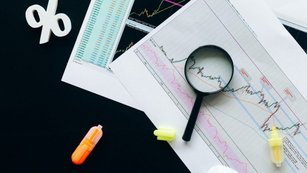 magnifying glass with data and percentage symbol in the background
