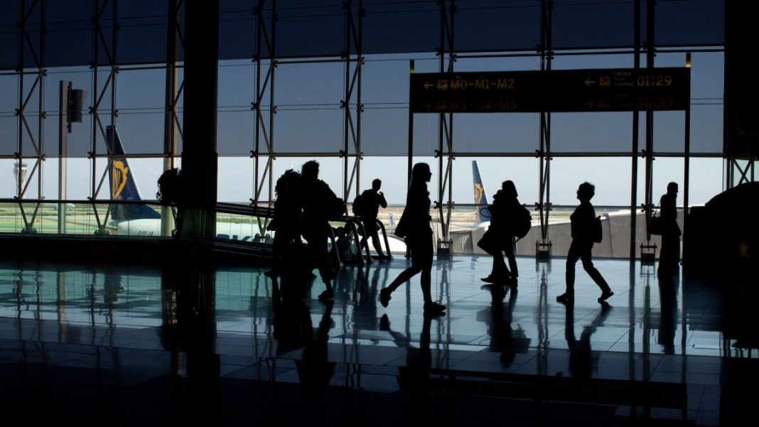 travelers with luggage at the airport silhouettes