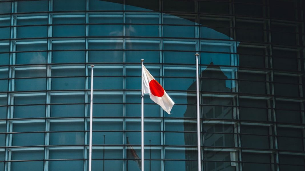 japan flag on pole glass building background