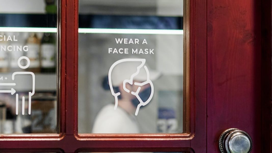 wear a mask sticker on glass and wooden door
