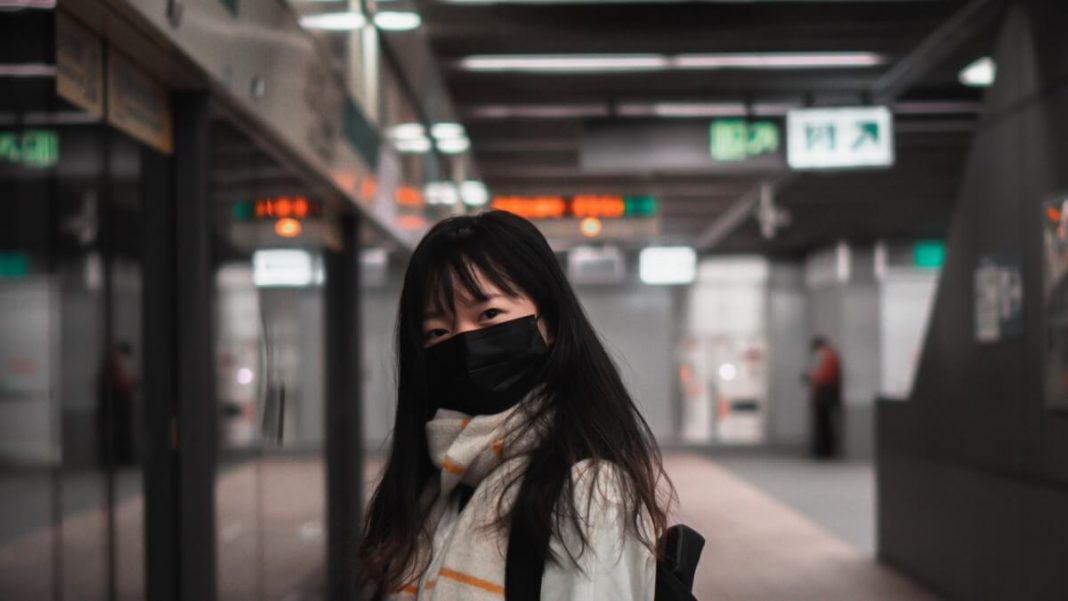 woman with black mask at the train station