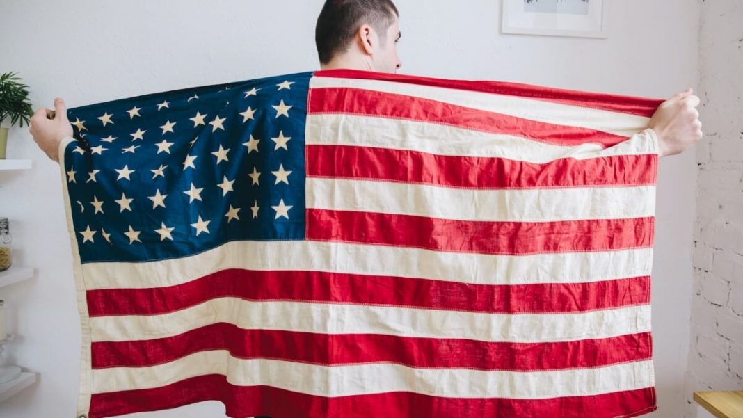man holding american flag in his back