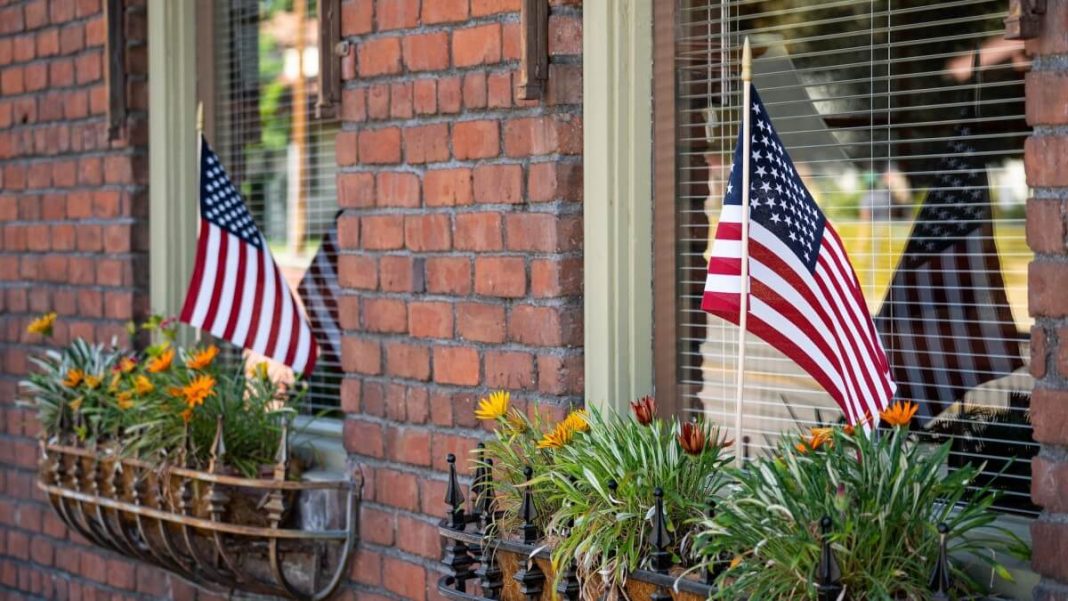 us flags pinned on flowerpots
