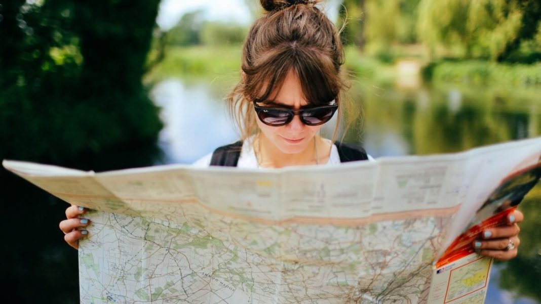 girl with sunglasses holding tourist map