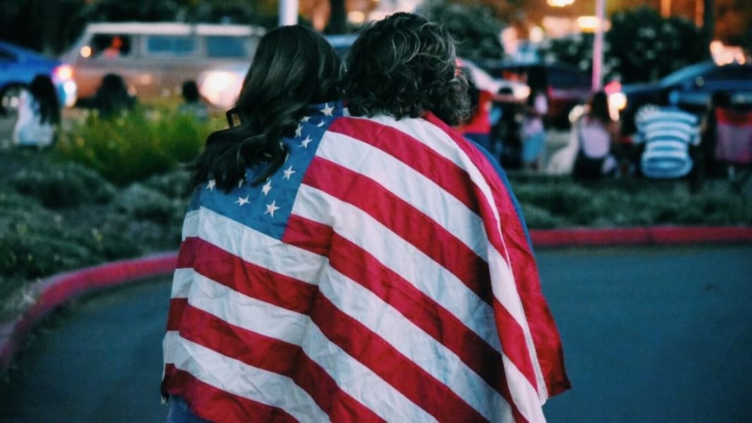 2 people with us flag on their backs