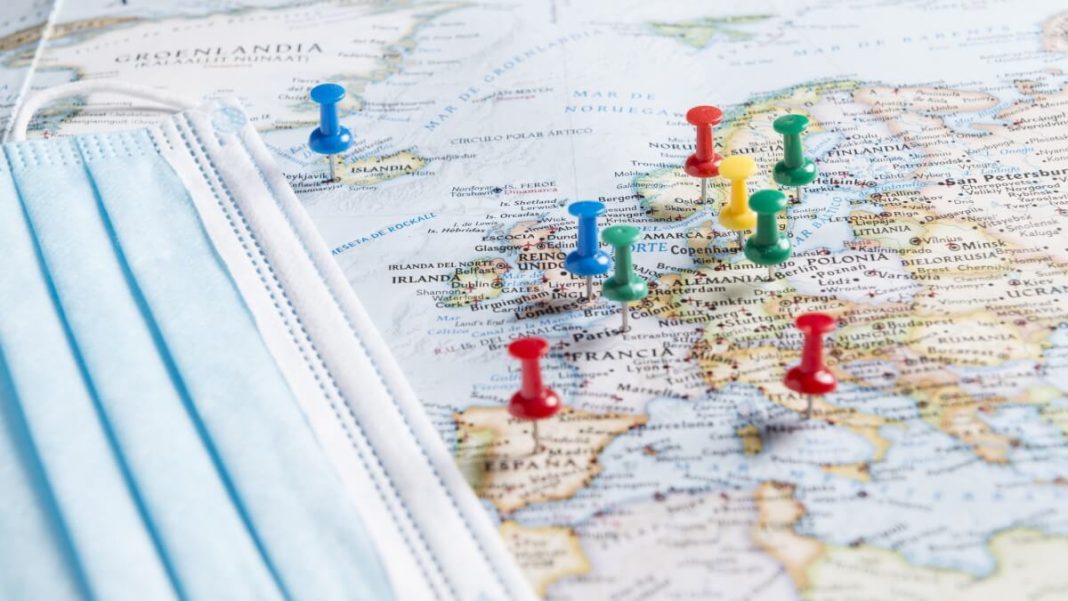 thumbtacks pinned and face mask on a map of europe