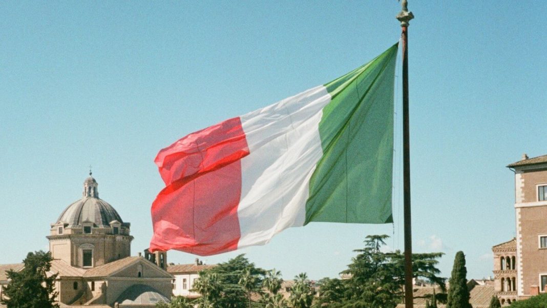 italy flag waving on flagpole city of rome view