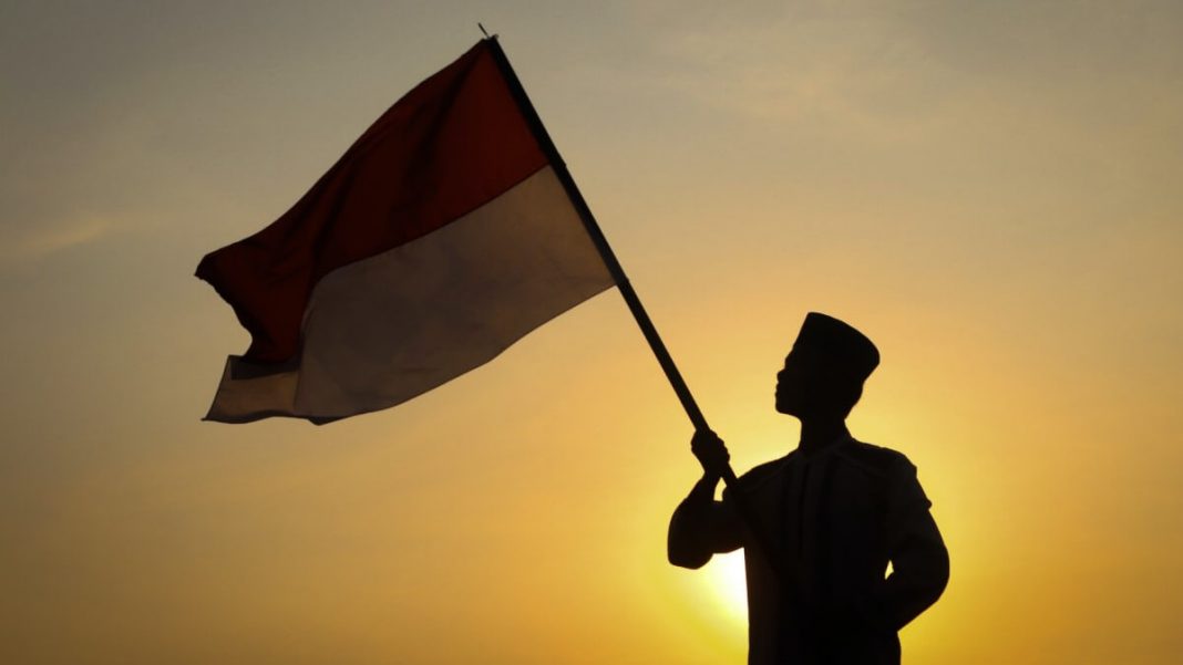 indonesian air force military soldier holding indonesia flag sunset view