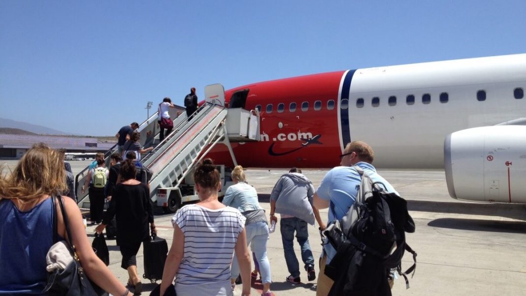 passengers entering white red airplane