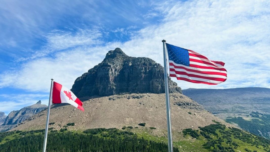 usa canada flag waving in front of mountain view