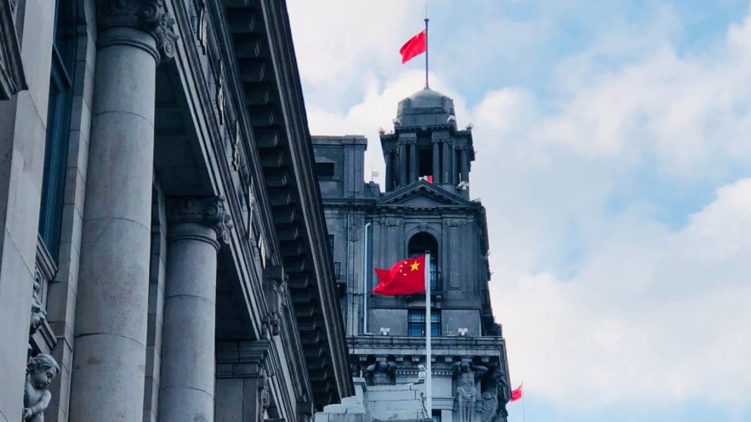 china flags waving up in hunagpu building shanghai china