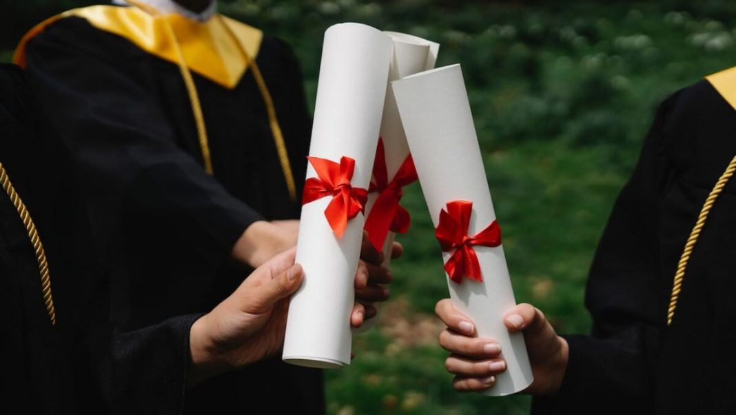 graduates holding white diplomas