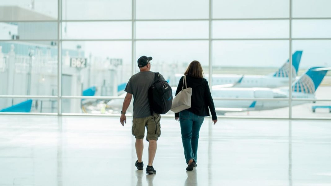 man and woman walking on airport halls