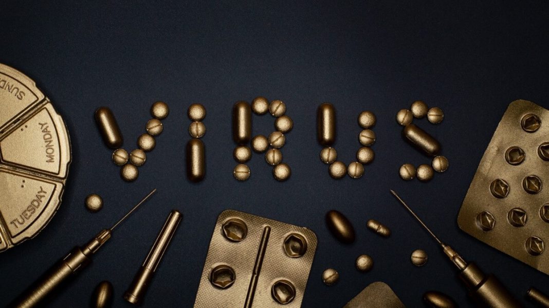 golden plastic syringes and pills virus text black background