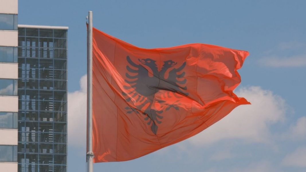 flag of albania with building on background