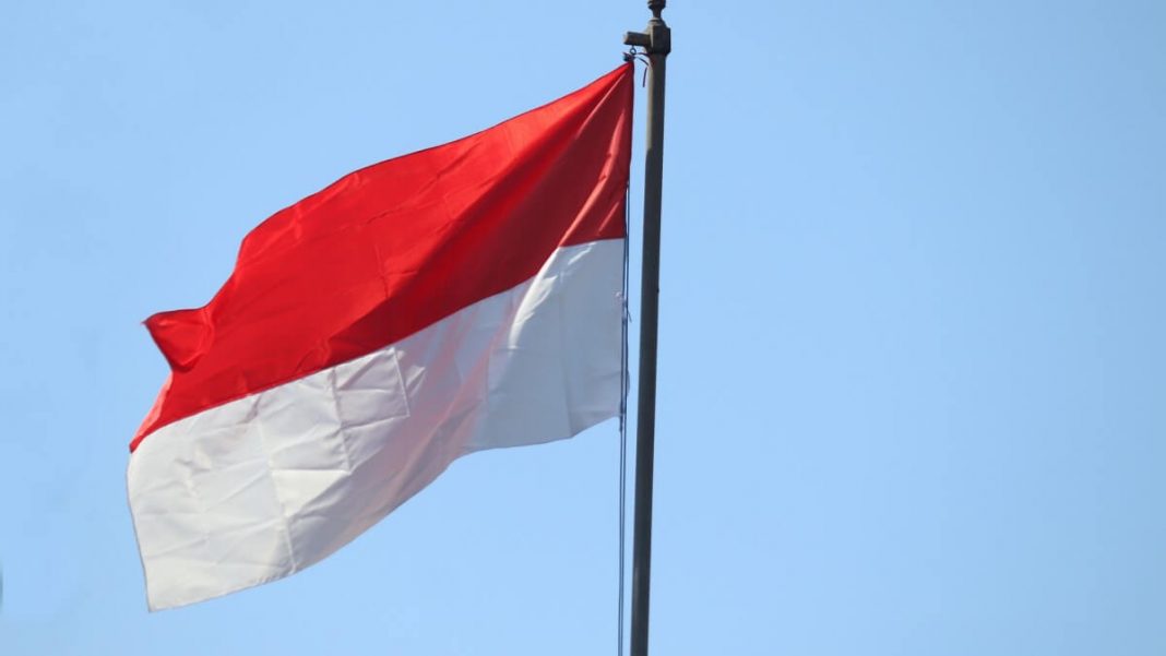 indonesia flag waving up on a flagpole blue sky background