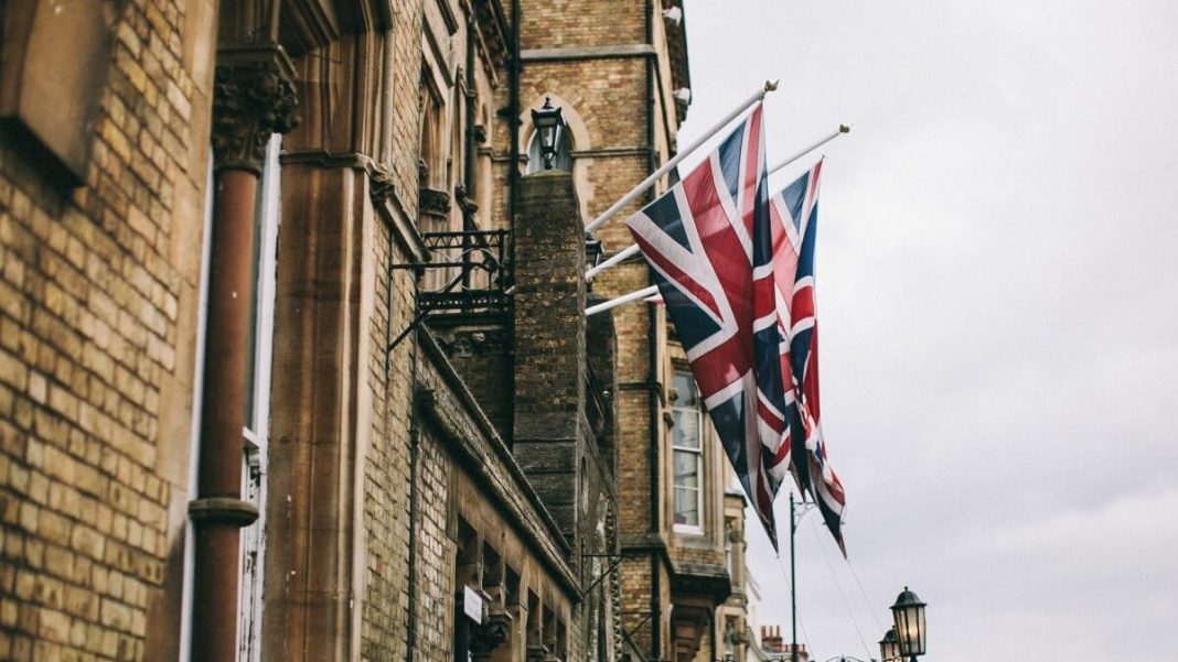 uk flags hanged on brown old building