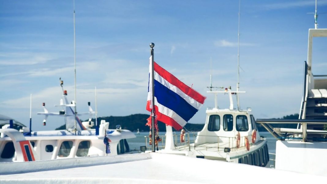 thailand flag waving up on small white yacht
